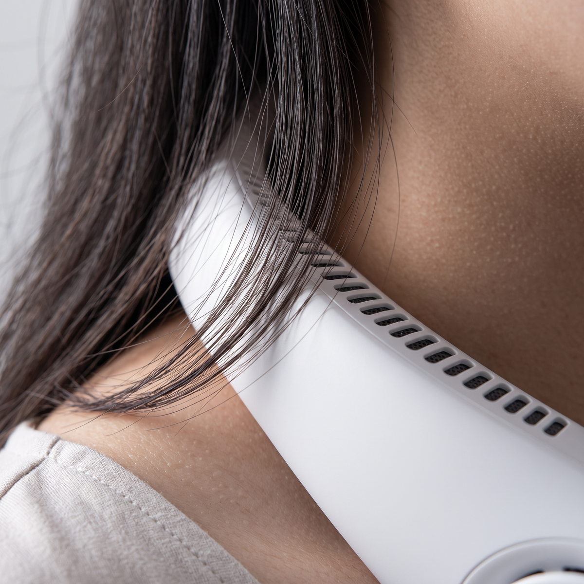 Dettaglio macro: capelli lunghi appoggiati sulla scocca chiusa del Ventolieve GO, nessuna pala esposta